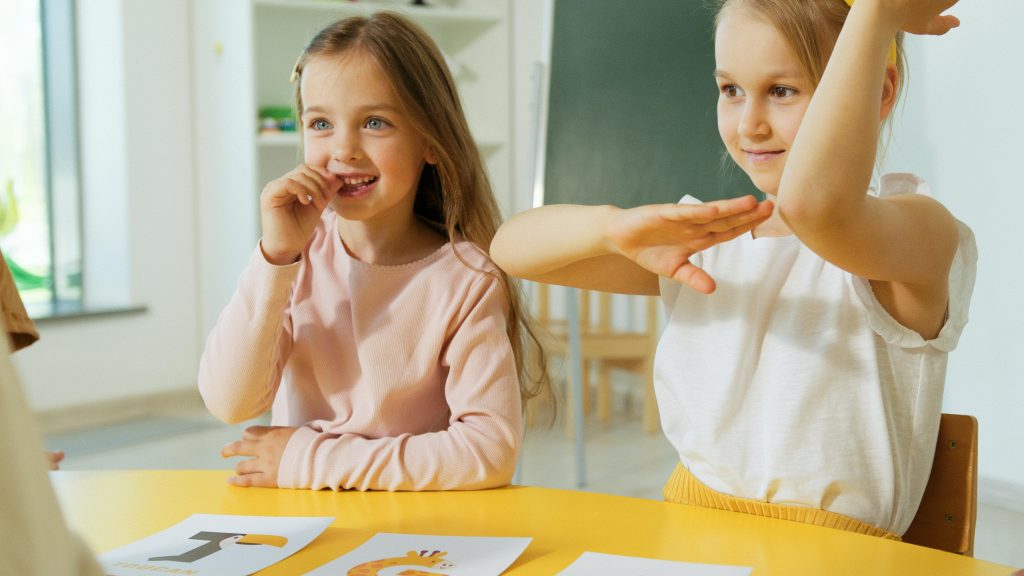 Two young girls happily engaging in educational activities at school, showcasing how the primary schools in "German Education System" look like.
